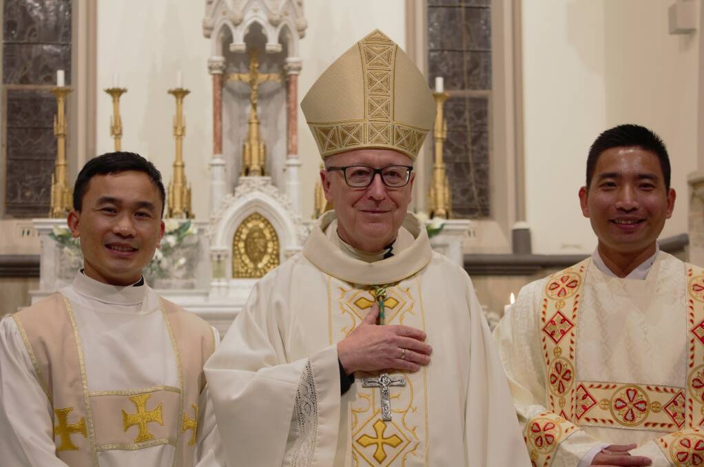 SPECIAL MOMENT: Bishop Michael McKenna with deacons Diep Quang Nguyen and Thao Van Nguyen.