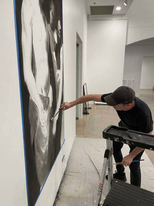 Luke Thurgate works on his temporary drawing on one of the walls at Bathurst Regional Art Gallery.