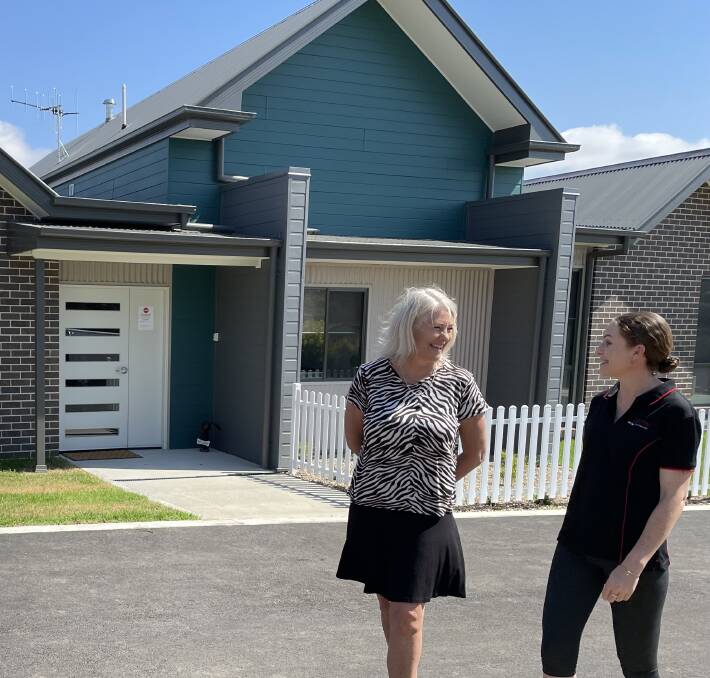 Glenray general manager Kath Graham and staff member Wendy Ashworth outside the new four-bedroom home at the village that was recently completed.