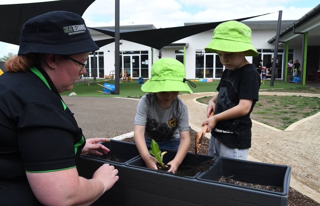 DIG DEEP: Great Beginnings assistant centre manager Liz Cozens and William and Liam plant lettuce.