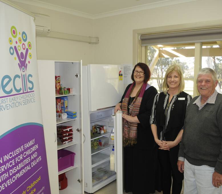 WELCOME ADDITION: Bron Hatton and Jo Hall of Bathurst Early Childhood Intervention Service with Bathurst RSL Club president Ian Miller and the pantry and fridge and freezer the club donated to the service. Photo:CHRIS SEABROOK 081616cfridge1