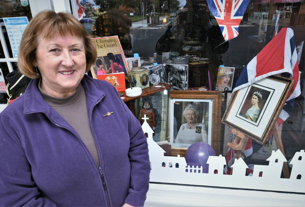 ROYAL OCCASION: Judy King from King's Antiques with a window homage to the Queen's seven decades on the throne. Photo: CHRIS SEABROOK 060122cjubilee