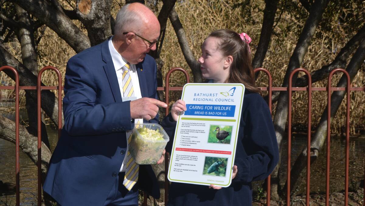 GOOD ADVICE: Mayor Graeme Hanger and student Montana Single with one of the new signs advising park visitors not to feed bread to the ducks. 080818ducks