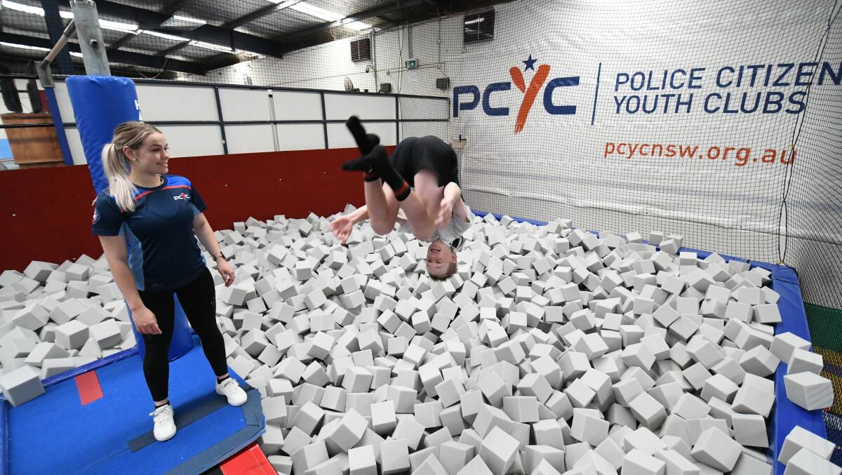 FOAM ZONE: PCYC gym co-ordinator Lauren Clemens watches year eight Kelso High student William Foskett, 14, try out the new foam pit. Photo: CHRIS SEABROOK 110619cfoam1