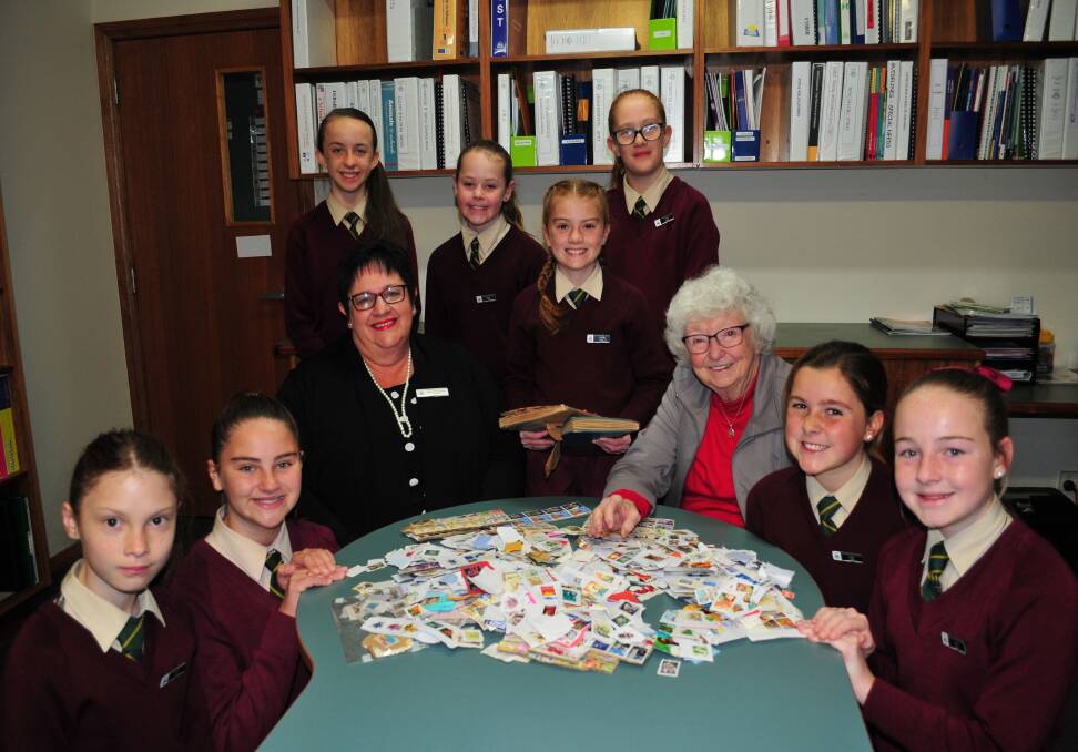 STAMPING OUT POVERTY: Assumption School principal Sue Guilfoyle and former school principal, Sr Jean Cain, with students Annalise Long, Ashlee Norris, Ashlee Pepper, Grace Davis, Jessica Miller, Ashley Larsen, Annabelle Jones and Elizabeth Schumacher. 
