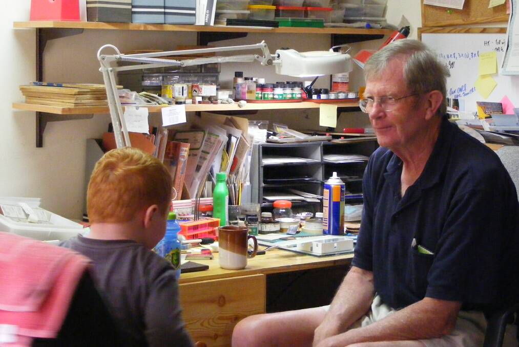 MAN WITH THE PLAN: John Brown, who created the model Tarana to Bathurst railway line, at his modelling desk with his grandson Max.