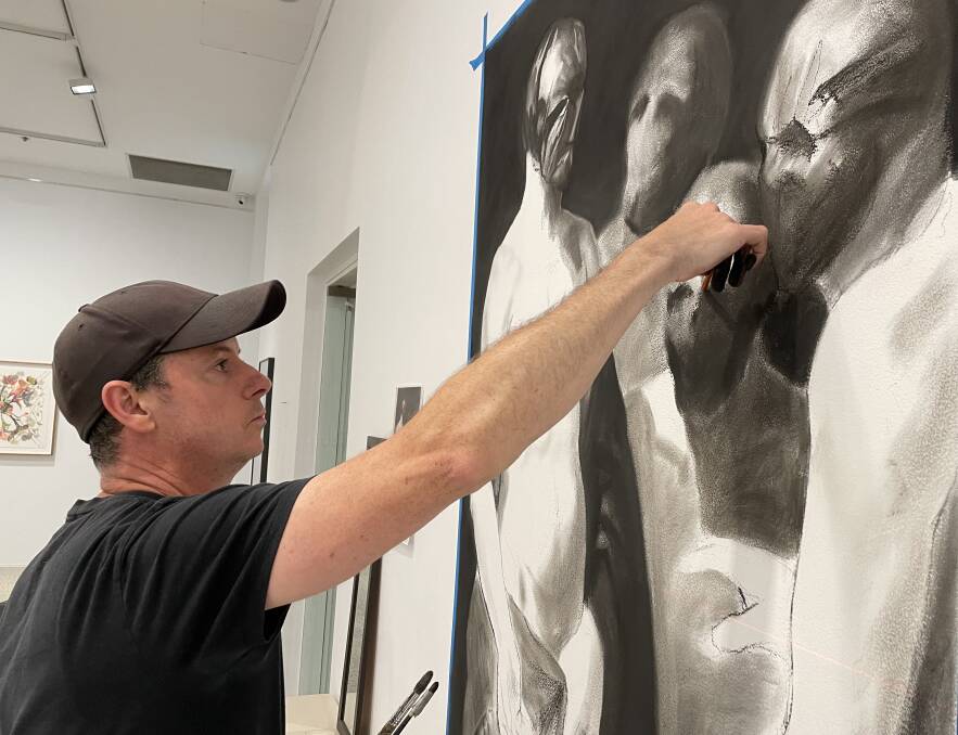 Luke Thurgate works on his temporary drawing on one of the walls at Bathurst Regional Art Gallery. 