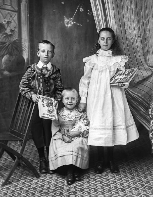 The children in this photograph, dated 1901, are all holding gifts.
