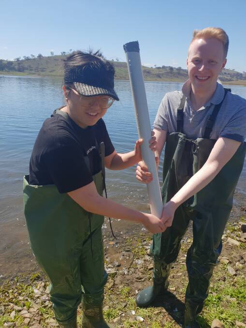 QUESTIONS: Student researcher Fayanne Cui and her university classmate Lachlan Mitchell collecting a soil core from Chifley Dam. 