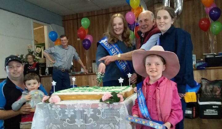 FIRST CUT: Showgirl Brooke Stanton and Clive Brabham cut the 60th anniversary cake at the Burraga Sheep Show.