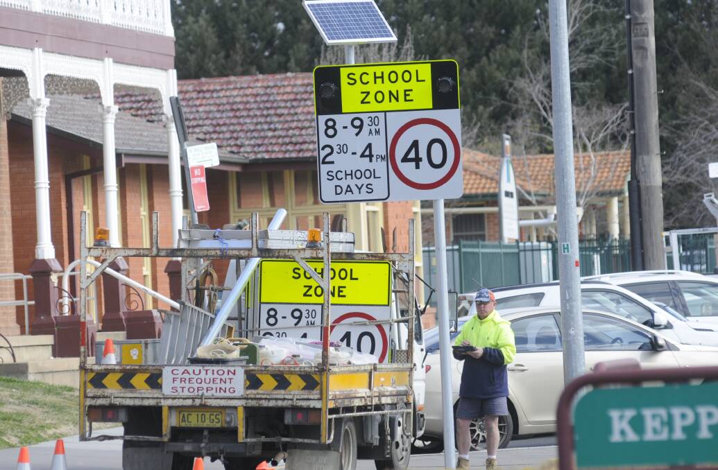 Flashback: A technician prepares to switch on a newly installed flashing school zone sign on the approach to the Cathedral School in 2015. Picture by Chris Seabrook