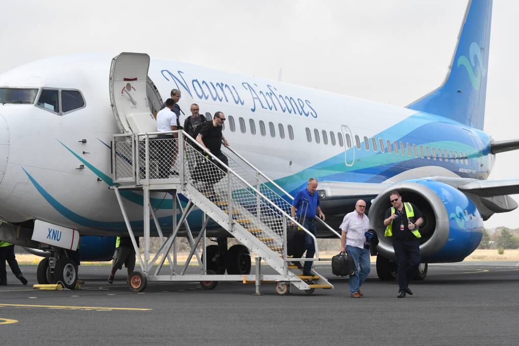 BIG BIRD: Elton John's tour crew disembark from the chartered Boeing 737-300 at Orange Regional Airport. Photo: JUDE KEOGH