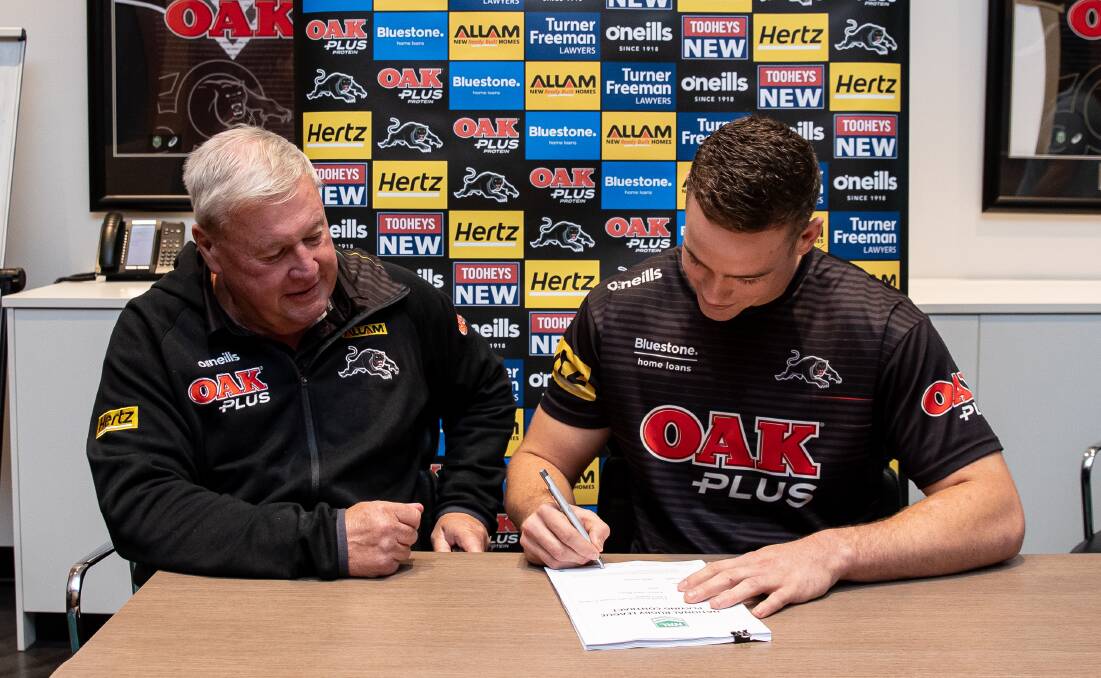SIGNING UP: Penrith's Jim Jones watches as Blayney Bear product Liam Henry inks his new deal with the club. Photo: PENRITH PANTHERS