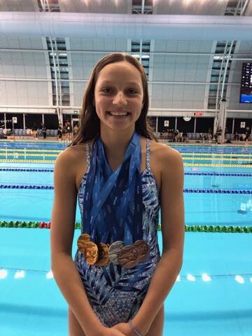 STAR SWIMMER: Collette Lyons with her impressive medal haul from the 2019 Australian Age Swimming Championships.