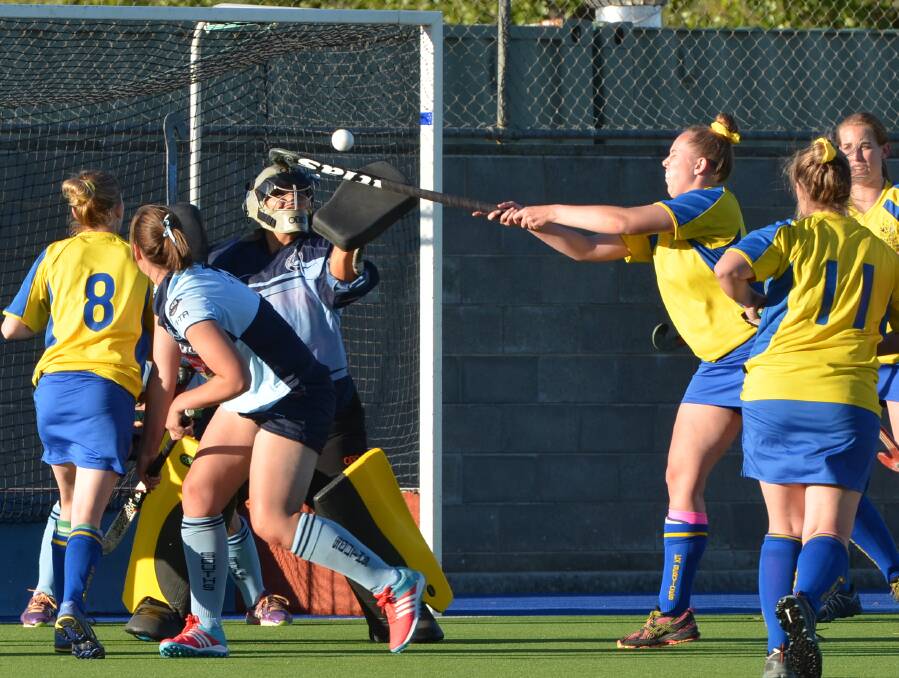 DENIED: Souths goalkeeper Kate Brown gets her glove to the ball as Exies pressure off a penalty corner. Photo: ANYA WHITELAW