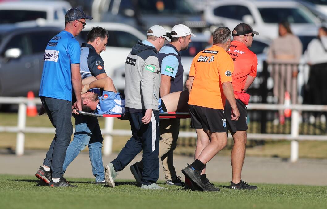 SCARY MOMENT: Group 10 hooker Nick Loader is carried from the field after injuring his right leg against Group 11. Photo: PHIL BLATCH