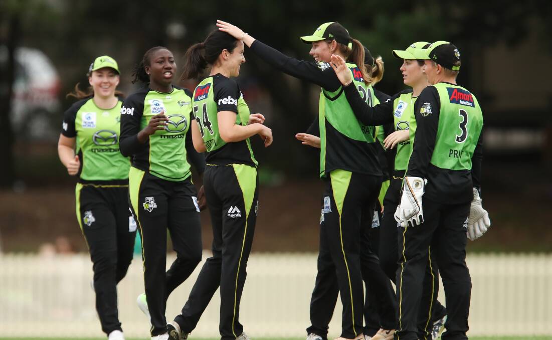 NICE WORK LG: Lisa Griffith is congratulated by her Sydney Thunder team-mates for snaring a wicket in the penultimate over. Photo: AAP