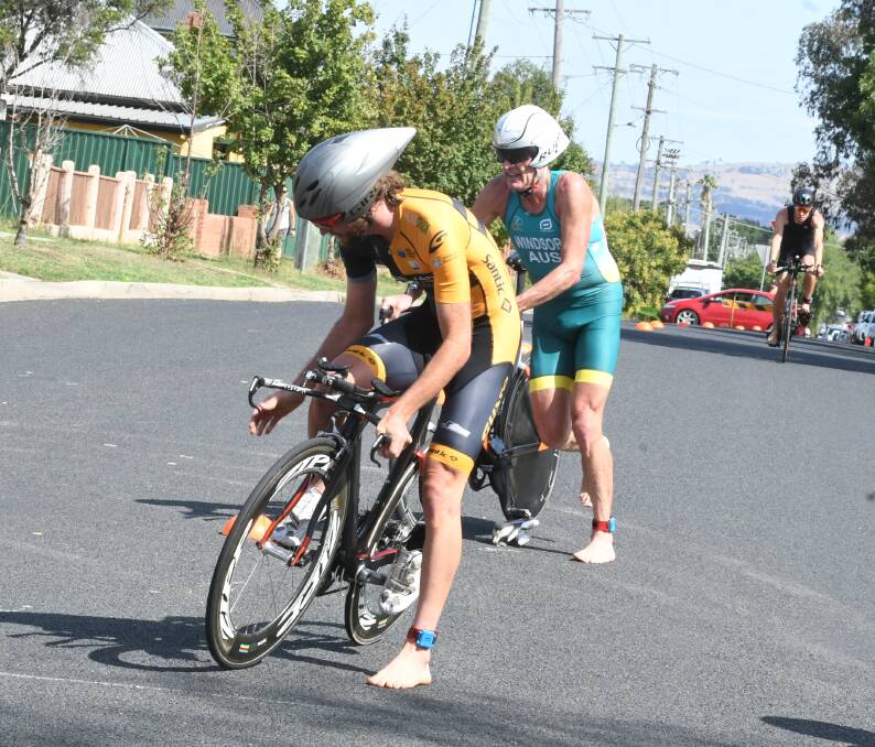 FRIENDLY RIVALRY: Mark Windsor and Tim Guy complete the 16km cycle leg within a fraction of a second of each other. Photo: CHRIS SEABROOK