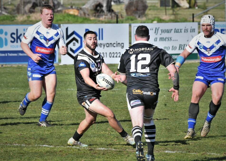 A TOUGH SEASON: Cowra Magpies' Jack Grant hands the ball off to David Doran in Sunday's game against St Pat's. Photo: CHRIS SEABROOK