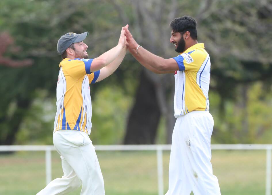 NICE JOB: Rugby Union captain Sam Macpherson congratulates Pirenu Nirmalendran after taking a wicket. Both have been in good touch so far this season. Photo: PHIL BLATCH