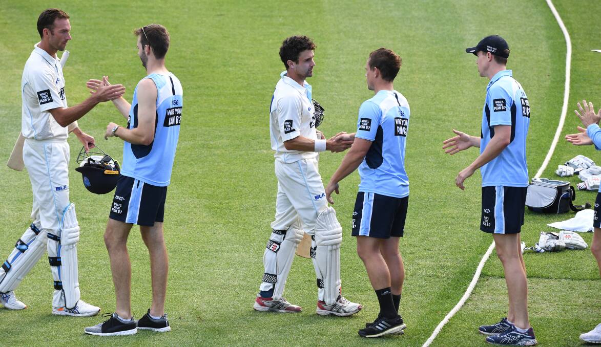 WELL DONE: Trent Copeland (left) and Ed Cowan are congratulated by their NSW team-mates after they forced a draw with Victoria. Photo: AAP