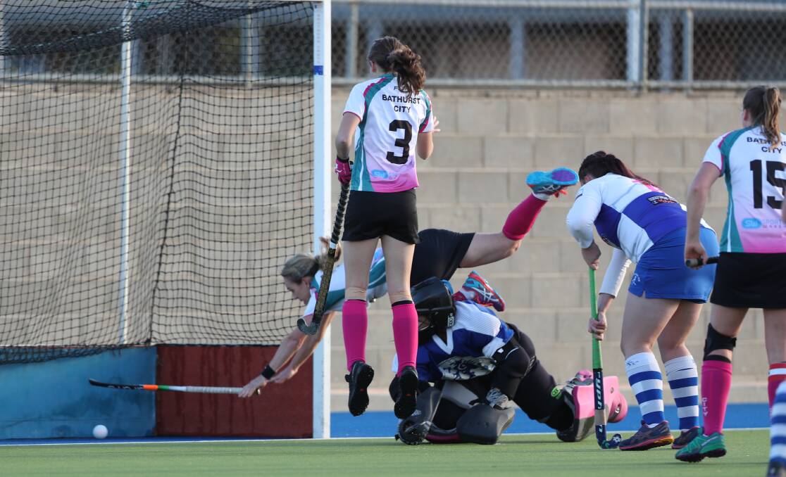 EFFORT: Bathurst City coach Lisa Quinn launches herself over St Pat's goalkeeper Lilli-Rai Campbell to ensure her shot finds the target. Photo: PHIL BLATCH