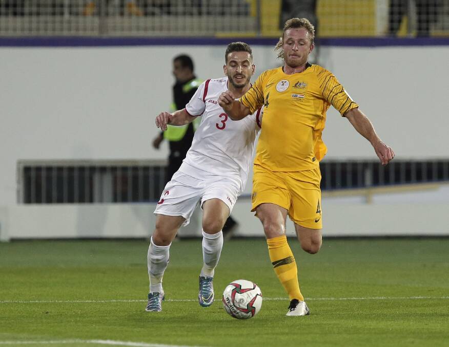 IN GREEN AND GOLD: Rhyan Grant beats a Syrian rival during the Socceroos 
final pool game at the AFC Asian Cup. He and his team-mates now face Uzbekistan in the round of 16. Photo: AP