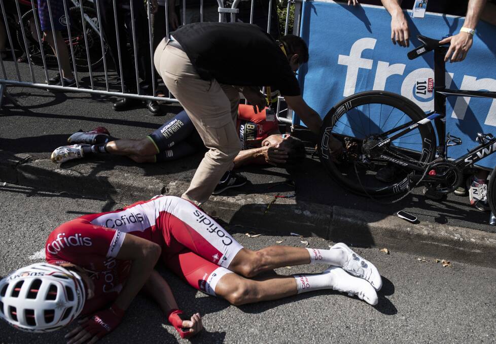 CARNAGE: Australia's Heinrich Haussler, rear, and Jesus Herrada of Spain receive medical attention after they crashed during the second stage of the Tour de France. Photo: AP