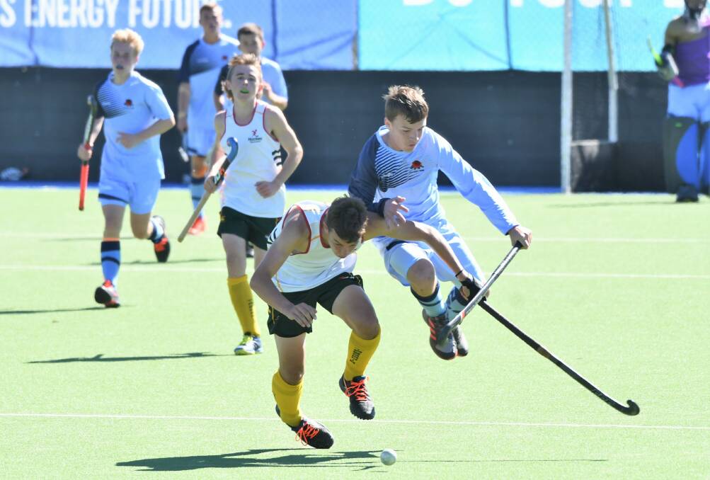 CHALLENGE: NSW State's Josh Robson collides with a Tasmanian rival during their final pool game at the Under 15 Australian Championships. Photo: CHRIS SEABROOK 041321cnswboys1