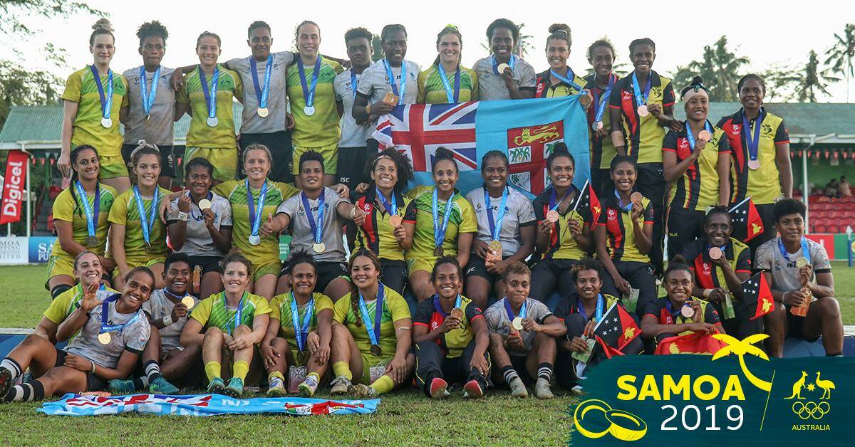 GOOD SPIRIT: Jakiya Whitfeld, back behind flag, poses with her fellow Pacific Games medallists. Photo: AUS OLYMPIC TEAM TWITTER