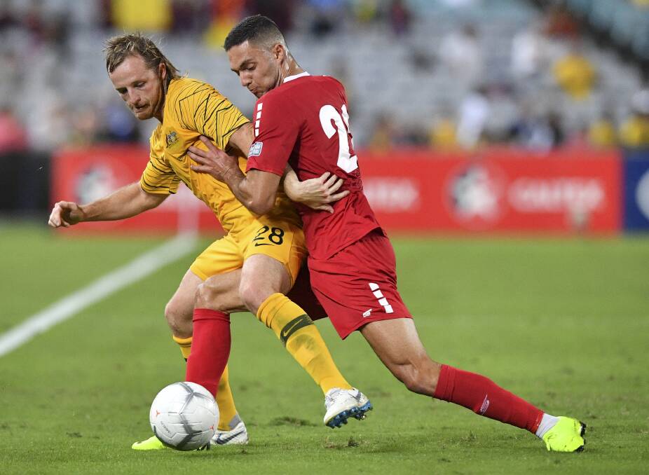 BIG NIGHT: Bathurst District Football Association graduate Rhyan Grant competes for possession against Bassel Jradi of Lebanon during the Socceroos friendly. Photo: AAP