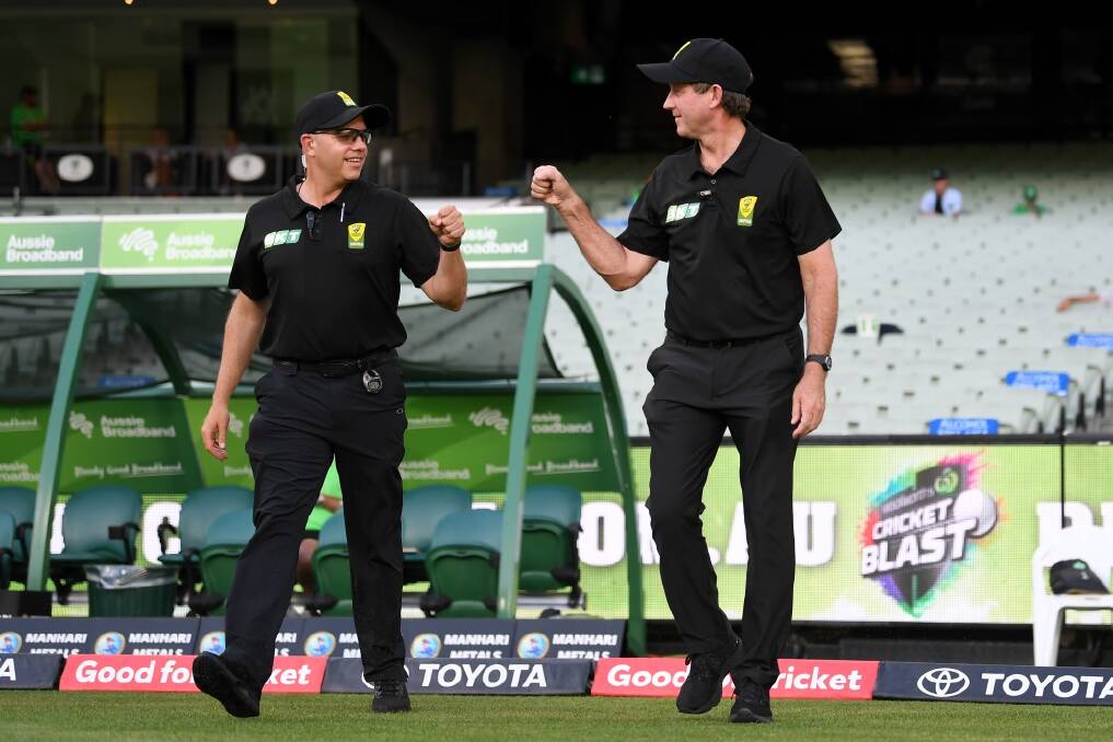 MILESTONE MOMENT: Bathurst umpire Tony Wilds (right) and Shawn Craig fist bump as Wilds walks out for his 50th BBL match. Photo: CRICKET AUSTRALIA