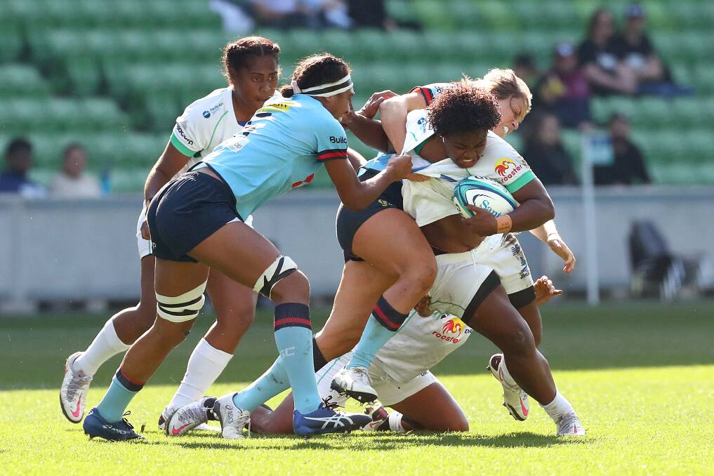 PHYSCIAL CHALLENGE: Grace Hamilton and her NSW team-mate Sera Naiqama try to bring down a Drua rival. Photo: GETTY IMAGES/NSW WARATAHS