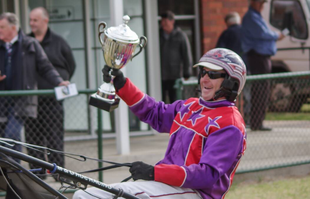 Mat Rue hoists the Waugoola Motors Centenary Cup after winning from the Angela Hedges-driven Ned Pepper. Photo: Robin Dale