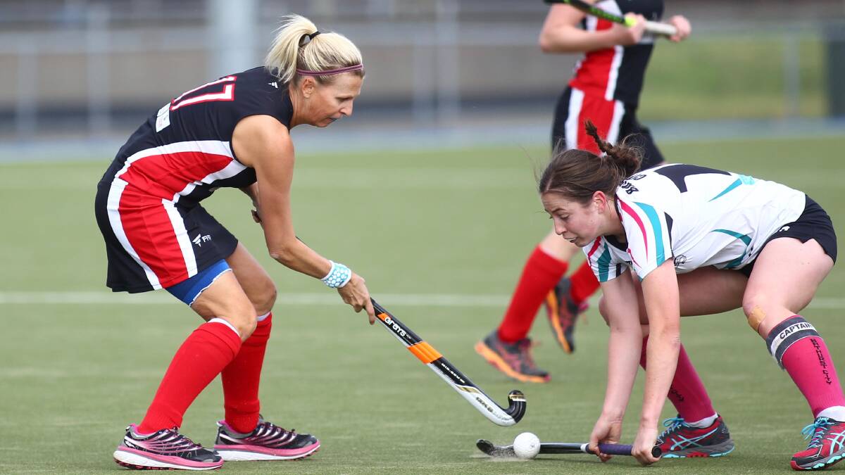 TACKLED: Bathurst City's Kelly Baker (right) takes the ball off Parkes rival Denise Gersbach in the women's Premier League Hockey competition. Photo: PHIL BLATCH