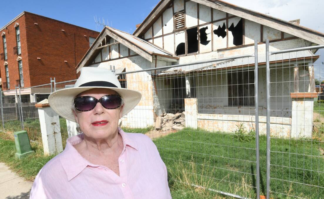 FALLING TO PIECES: Councillor Monica Morse outside one of two derelict homes at the lower end of William Street. Photo: CHRIS SEABROOK