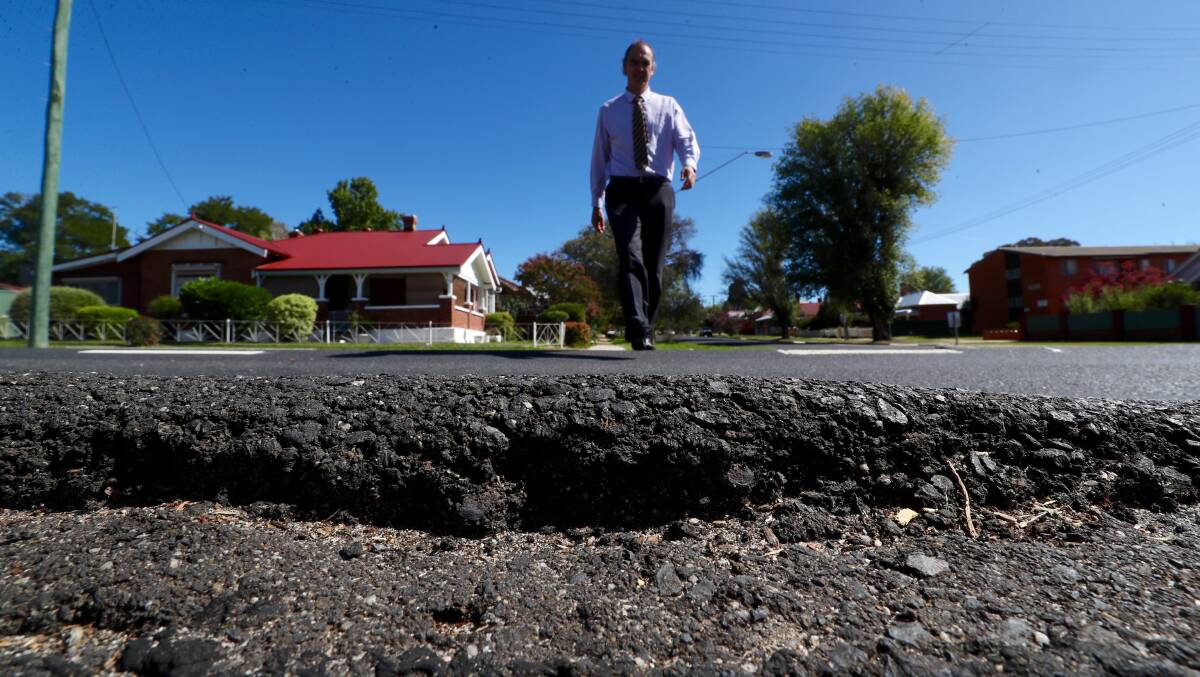 ROCKY ROAD: Resident Stuart Driver says the damaged road surface on a section of Stewart Street poses a potentially fatal trip hazard. Photo: PHIL BLATCH 