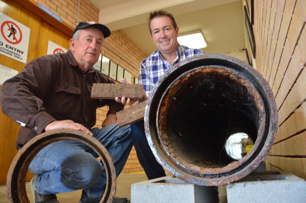 WATER: SECURITY: Deputy mayor Bobby Bourke and Bathurst MP Paul Toole with a section of the old wooden pipeline that was originally installed from Winburndale Dam to Bathurst. Photo: SUPPLIED