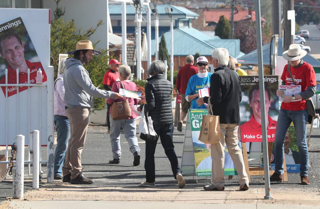DEMOCRACY: Volunteers hand out how-to-vote flyers outside the Bathurst early voting centre on Howick Street on Monday. Photo: PHIL BLATCH