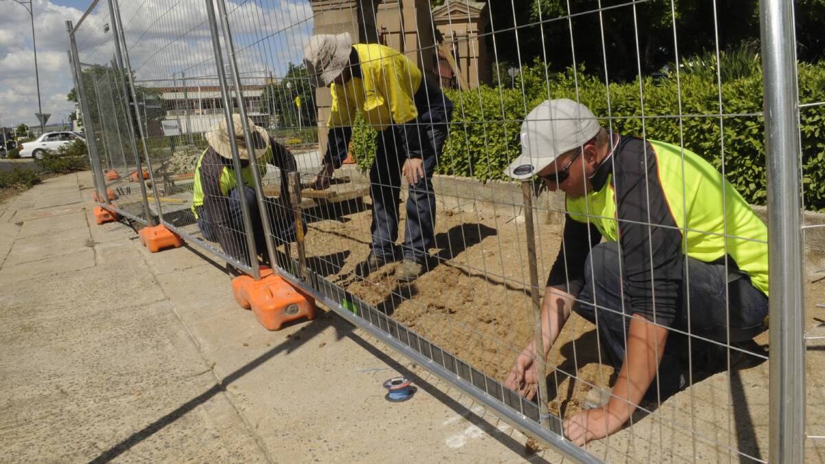 PAVING THE WAY: Bathurst Regional Council staff hard at work this week upgrading  the footpath outside the George and Russell street entrance to Machattie Park. Photo: CHRIS SEABROOK 110817cpave1