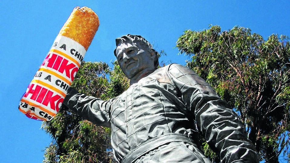 BATHURST ICONS: The statue of Peter Brock holding a big Chiko at the National Motor Racing Museum. Photo digitally altered