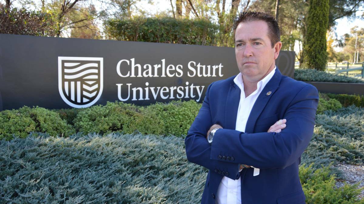TIME TO ACT: Member for Paul Toole, standing out the front of CSU's Bathurst campus, said the Federal Government should consider a quota system for international students.