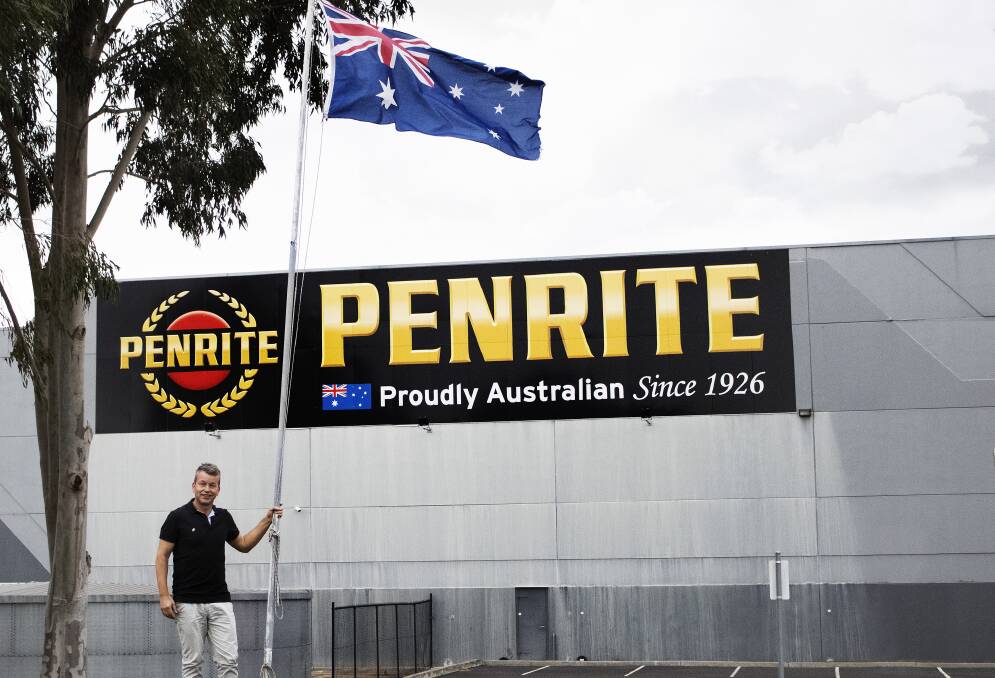 FLY THE FLAG: Penrite managing director Toby Dymond with the Australian flag flying outside the company's Melbourne manufacturing plant and distribution centre. Photo: SUPPLIED