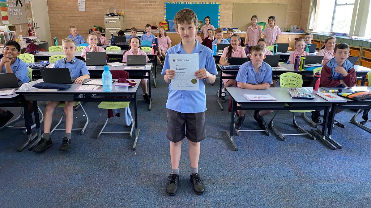 NUMBERS GAME: Holy Family Year 4 student Felix Lindsay with his University Certificate for outstanding mathematics. Photo: SUPPLIED