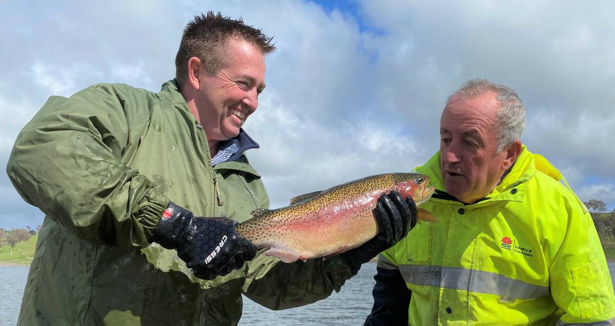 PUCKER UP: Bathurst MP Paul Toole and mayor Bobby Bourke with one of the rainbow trout released into Ben Chifley Dam. Photo: SUPPLIED