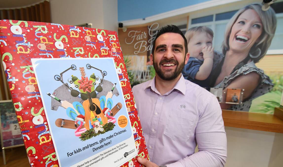 CLEAR AND PRESENT: Newcastle Permanent Bathurst branch assistant manager Nathan Shaw with a collection box for the Salvos. 