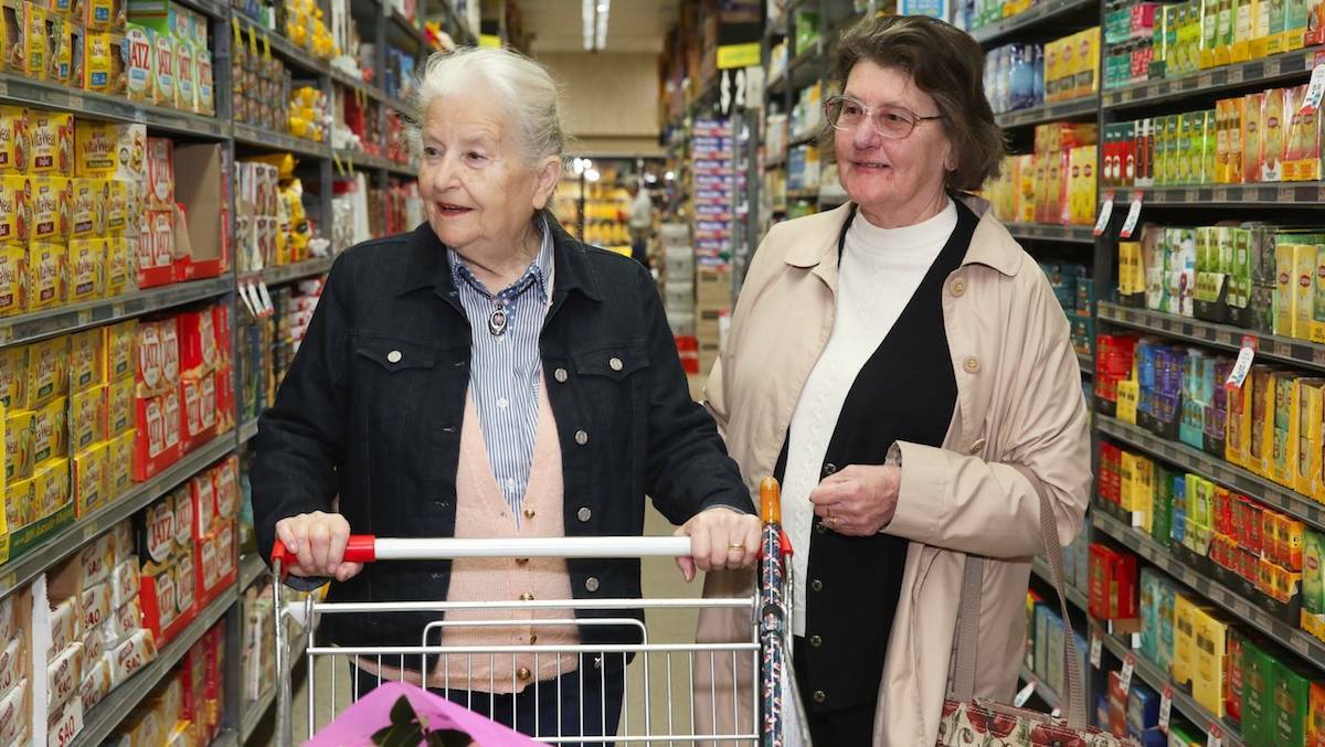 HELPING HAND: Accessible Living Options volunteer Helen Horne (right) is pictured Carla Henley with her shopping. Photo: SUPPLIED