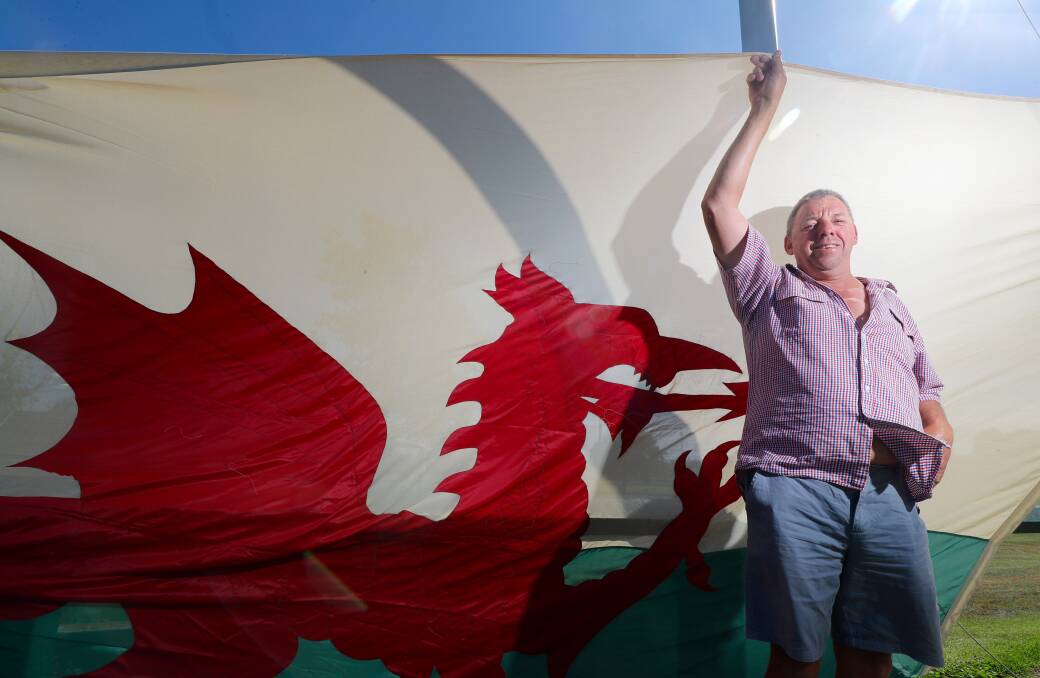 WELSH PRIDE: Bathurst man Terry James with the Welsh flag before it joined the Lions Club's display of flags on Saturday. Photo: PHIL BLATCH