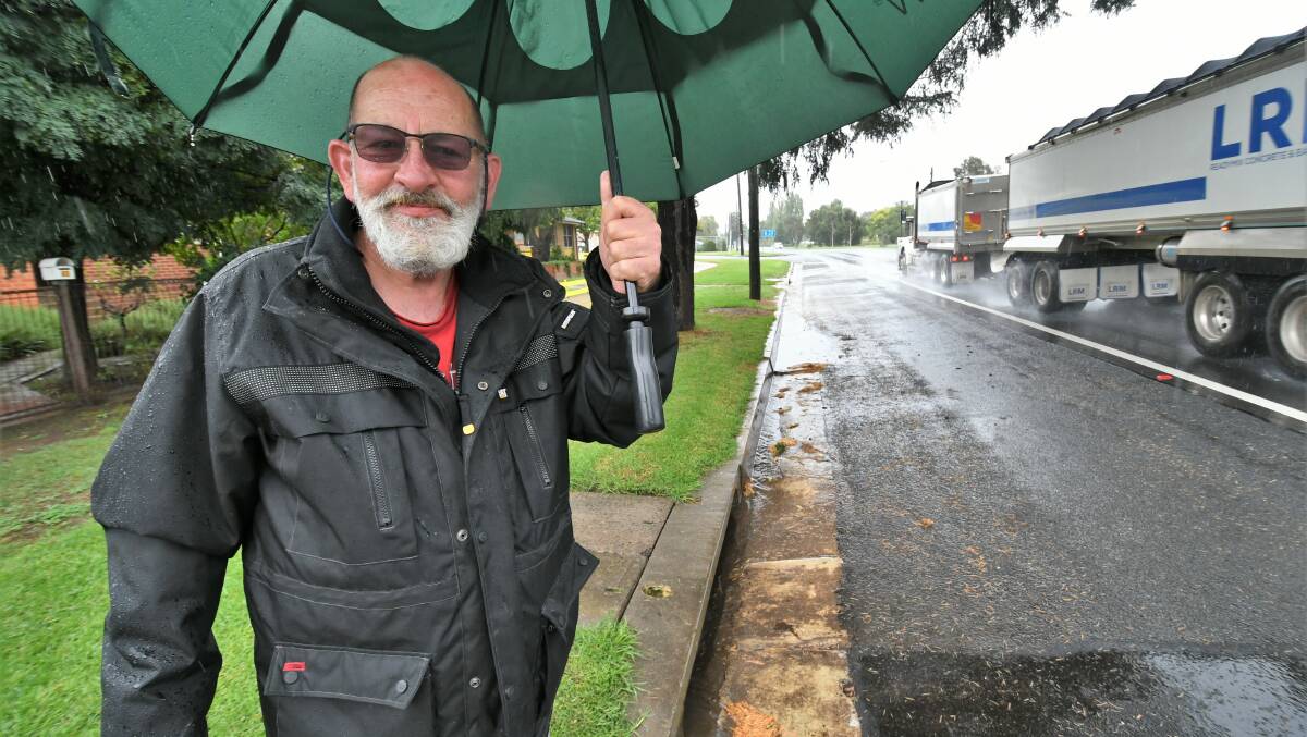 RAINING CHAMPION: Vittoria Street resident Mark Ryan near the unblocked stormwater drain which had been a problem for more than 40 years. Photo: CHRIS SEABROOK 032221cdrainage