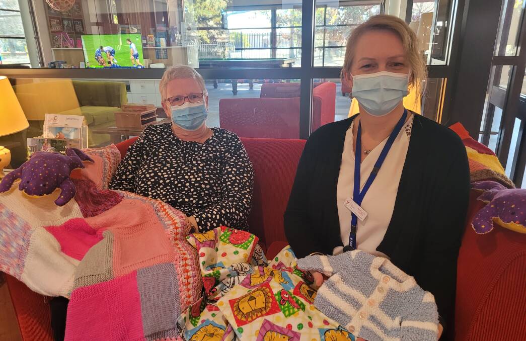 STITCH IN TIME: Annette McNabb from the Bathurst craft group with RMHC manager Bronwyn Cooper and a selection of some of the beautiful handcrafted baby items donated this week. Photo: SUPPLIED